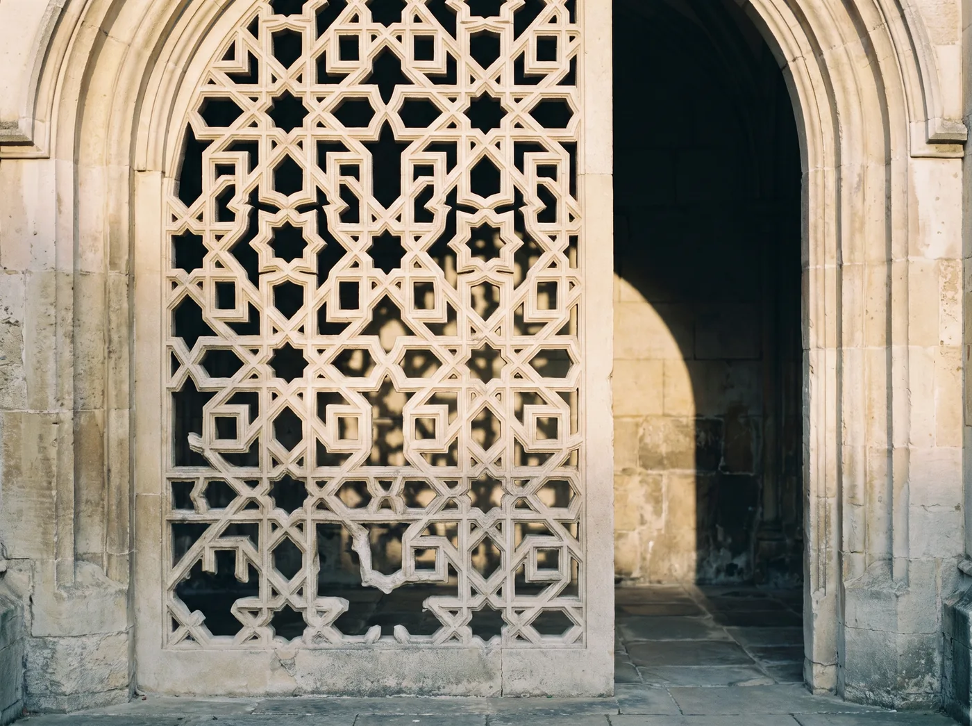 A carved mashrabiya screen filtering daylight